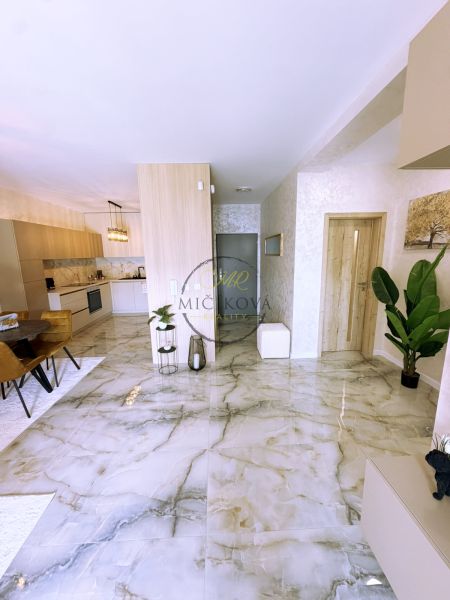 Innenraum einer 2-Zimmer-Wohnung mit Marmorboden, heller Küche und Esszimmer.