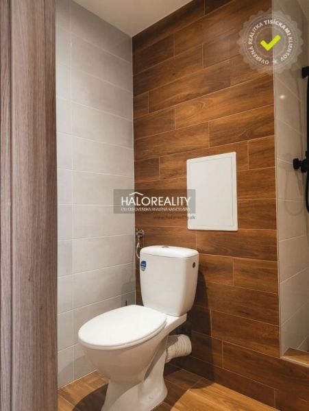 Badezimmer in einem Studio-Apartment mit Boden und Wand in Holzoptik.