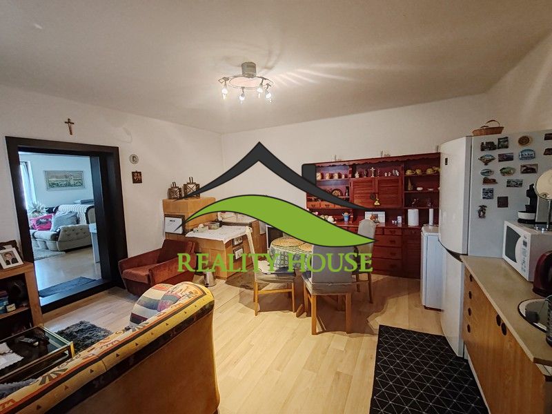 Wohnzimmer in einem Einfamilienhaus mit Holzboden und Kochnische.