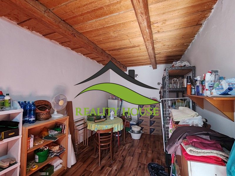 Ein Zimmer in einem Einfamilienhaus mit einem Boden in Holzoptik und Aufbewahrungsregalen.