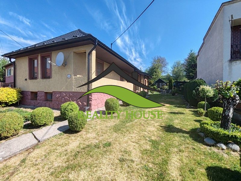 Ein Einfamilienhaus in der Hauptstraße in Banské mit einem gepflegten Garten und einem gepflegten Rasen.