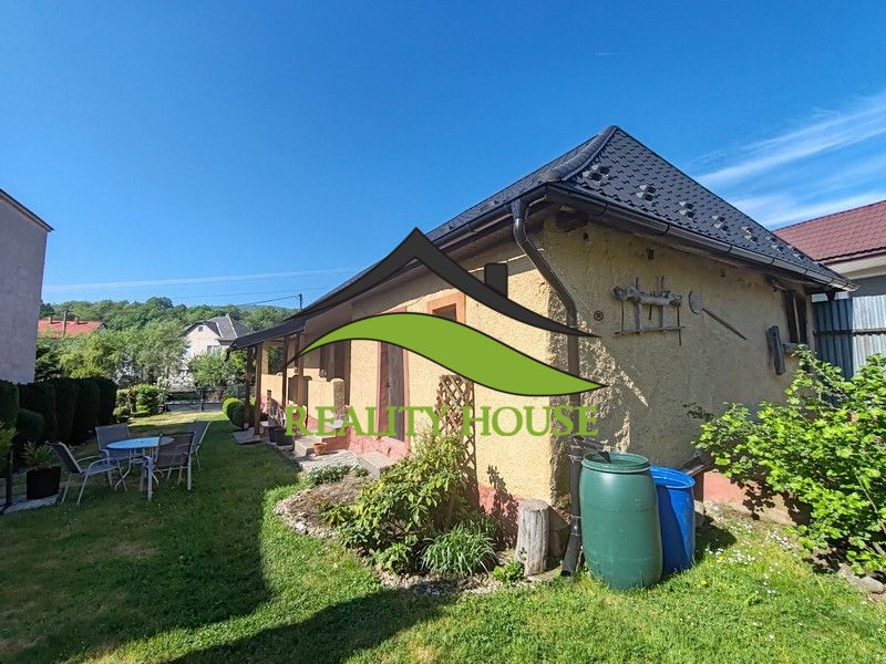 Das Einfamilienhaus in der Hauptstraße in Banské mit einem schönen Hof, Gartenmöbeln und Vegetation.