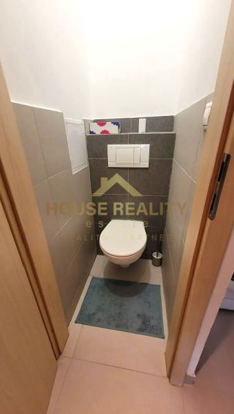 Kompakte Toilette mit Fliesen und Teppich in einer 3-Zimmer-Wohnung.