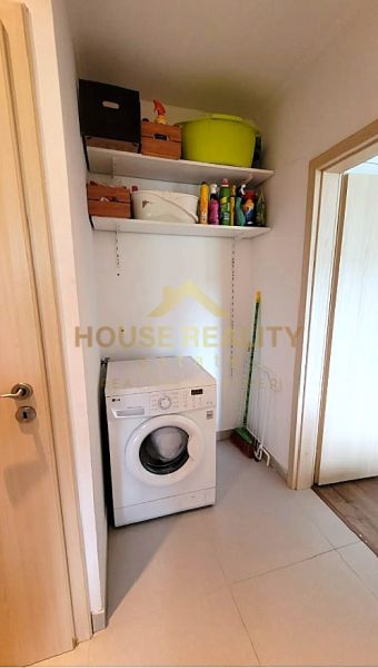 Waschmaschine mit Regalen für Reinigungsmittel und Mopp in einer 3-Zimmer-Wohnung.