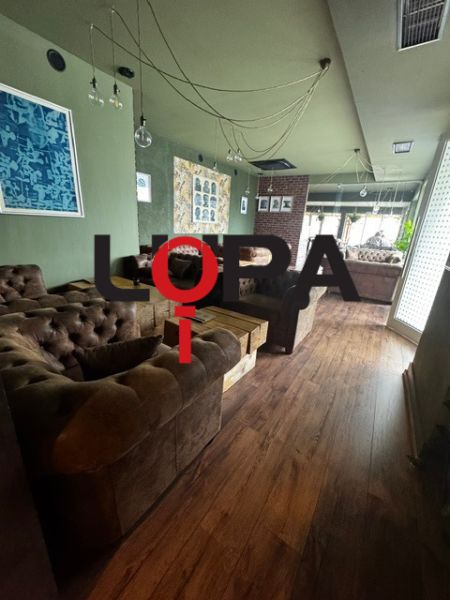 Innenräume von Geschäftsräumen mit bequemen Sofas und einem Boden in Holzoptik.