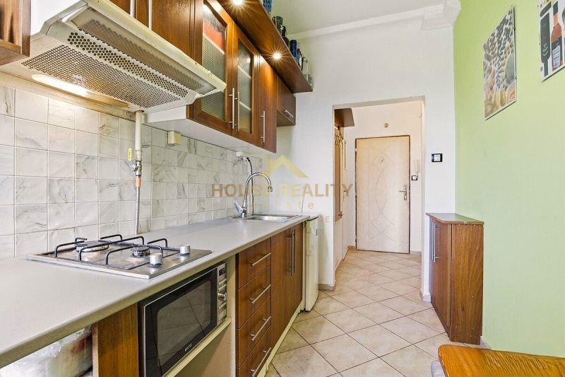 Küche in einer 2-Zimmer-Wohnung mit Gasherd, Mikrowelle und Stauraum.