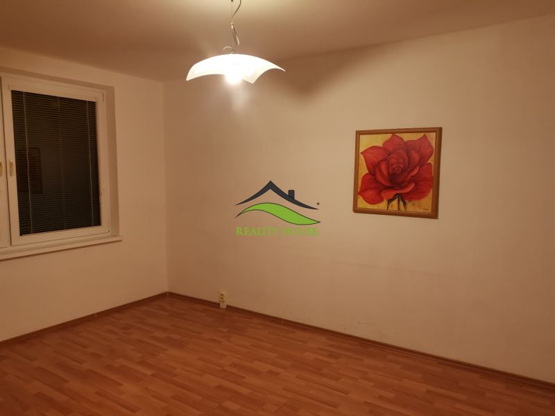 Ein Zimmer in einer 3-Zimmer-Wohnung mit einem Boden in Holzoptik und einem Rosenbild.
