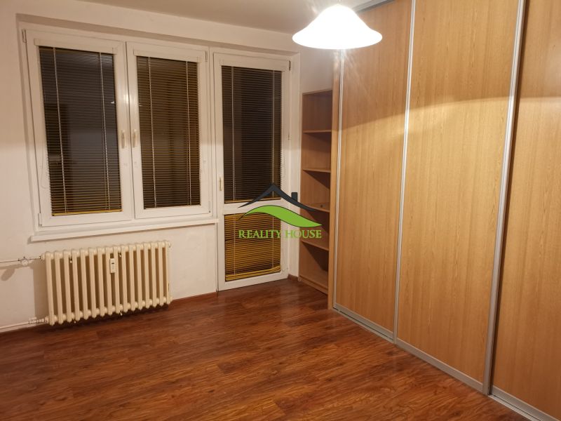 Ein Zimmer mit einem Holzboden und einem großen Einbauschrank in einer 3-Zimmer-Wohnung.