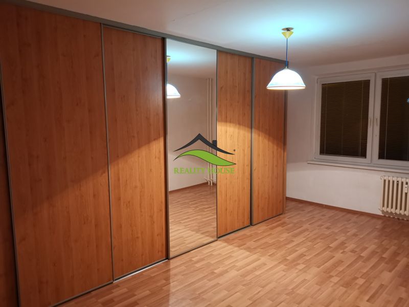 Ein Kleiderschrank mit Schiebetüren, Spiegel und einem Boden in Holzoptik in einer 3-Zimmer-Wohnung.