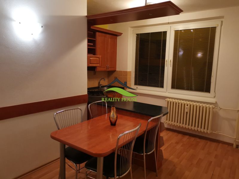 Küche in einer 3-Zimmer-Wohnung mit Holzboden und Esstisch.