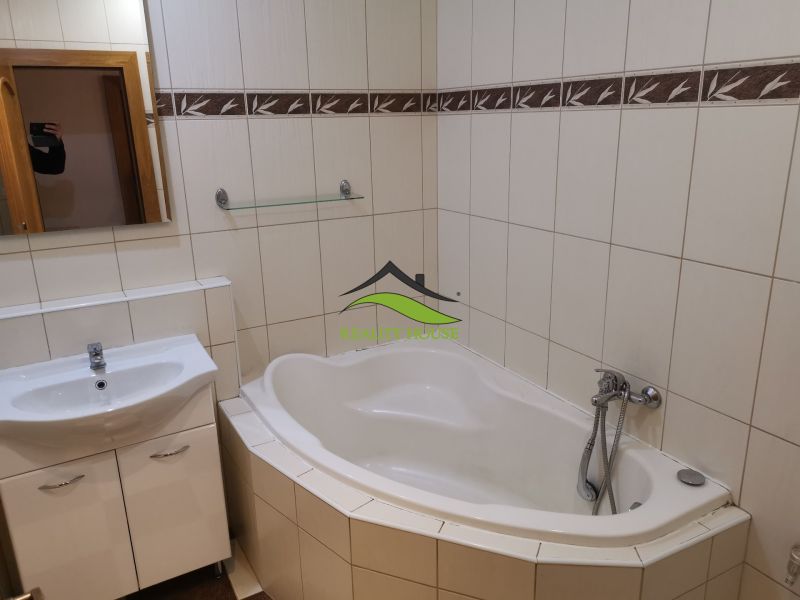 Badezimmer mit Badewanne und Waschbecken, helle Fliesen in einer 3-Zimmer-Wohnung.