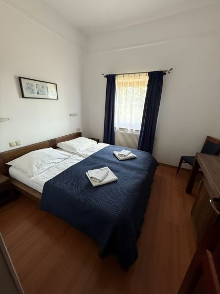 Ein Zimmer mit Doppelbett, blauer Bettdecke und Holzboden in Hotels und Pensionen.
