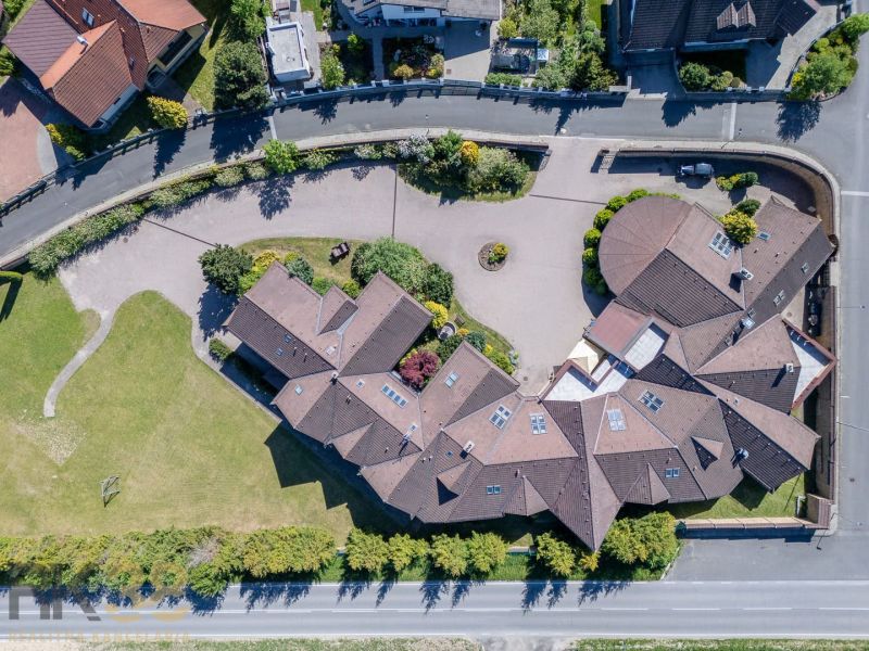 Luftaufnahme des Hotel- und Pensionskomplexes in Nová Lesná mit einem weitläufigen Hof und viel Grün.