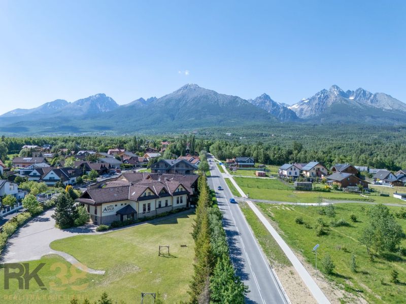 Ein Blick auf Hotels und Pensionen in Nová Lesná mit der Hohen Tatra im Hintergrund.