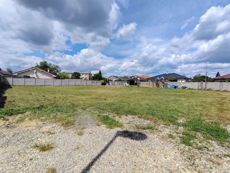 Baugrundstück in Kostolište in der Straße Za bytovkou mit gepflegtem Rasen und Umzäunung.