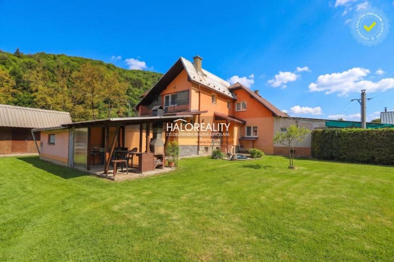 Ein Einfamilienhaus in Dolná Mariková mit Rasen und Pavillon in einer natürlichen Umgebung.