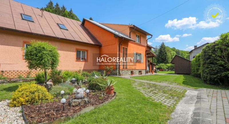Ein Einfamilienhaus in Dolná Mariková mit einer bunten Fassade, umgeben von einem grünen Garten und einem Gehweg.