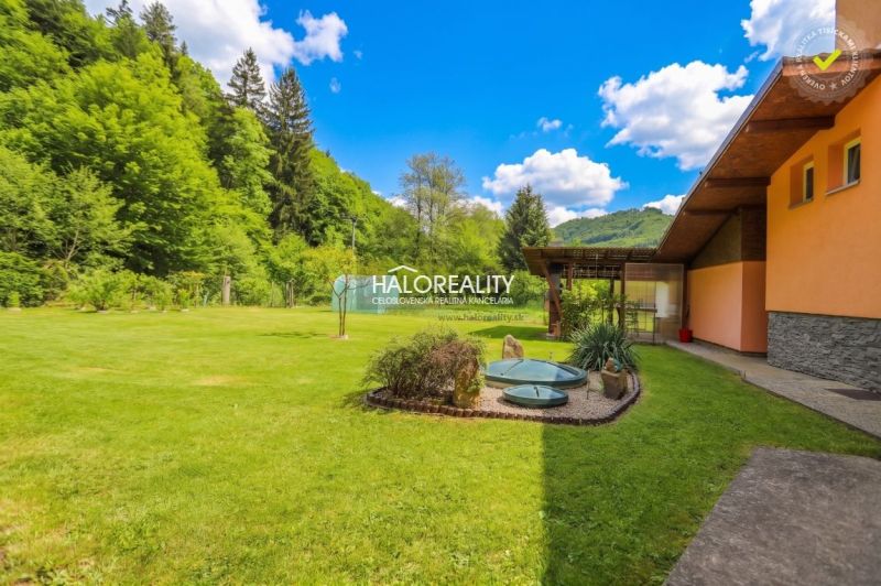 Garten bei einem Einfamilienhaus in Dolná Mariková mit Rasen und Zierpflanzen.