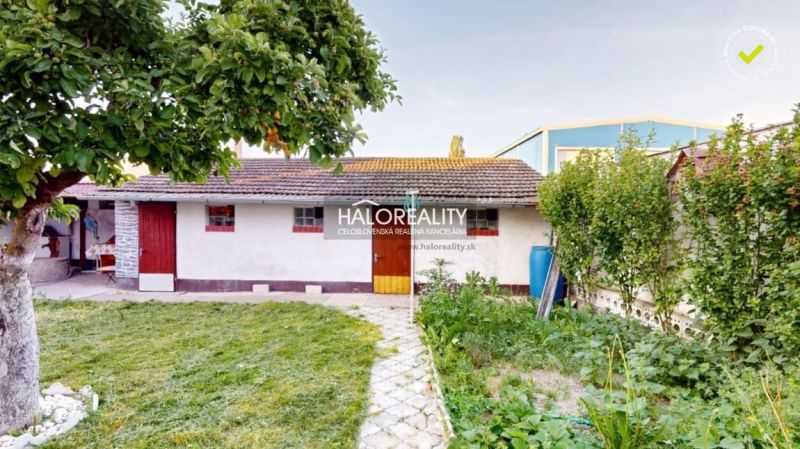 Ein Einfamilienhaus in Senica mit Garten, Bäumen und einem Gartenhaus.