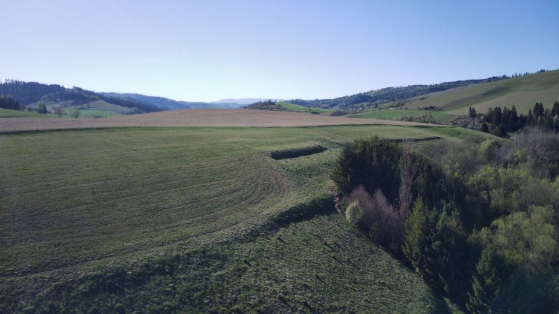 Die Landschaft rund um Čierny Balog mit landwirtschaftlichen und forstwirtschaftlichen Flächen an einem klaren Tag.
