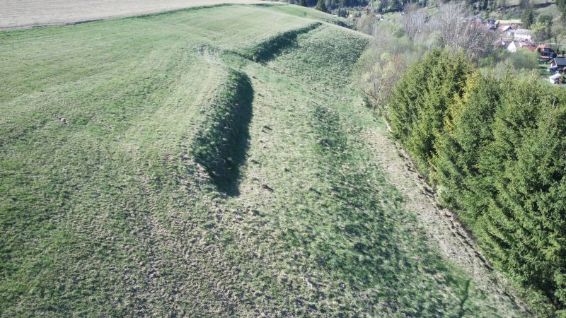 Landwirtschaftliche und forstwirtschaftliche Flächen in Čierny Balog mit Erhebungen und Nadelwald.