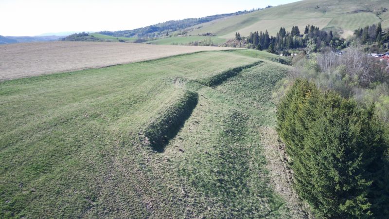 Grüne landwirtschaftliche und forstwirtschaftliche Flächen in Čierny Balog mit hügeliger Landschaft und Bäumen.