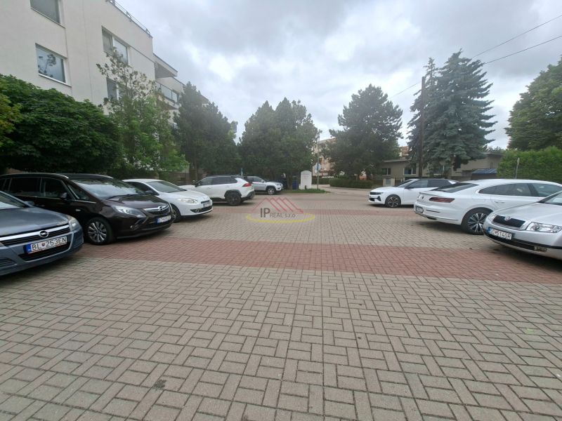 Parkplatz mit Autos in der Športová-Straße in Dunajská Lužná vor dem Gebäude.