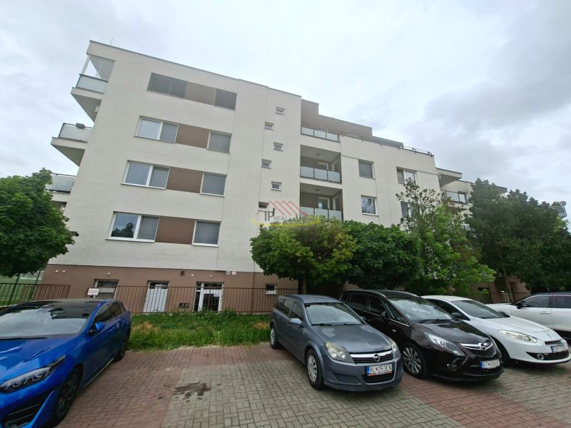 Wohnhaus in der Športová-Straße in Dunajská Lužná mit Parkplatz und Autos vor dem Gebäude.