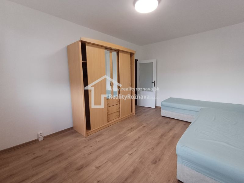 Ein Zimmer in einer 3-Zimmer-Wohnung mit einem Boden in Holzoptik und einem Kleiderschrank.