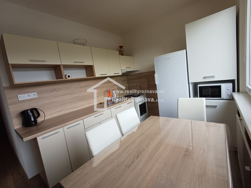 Küche mit Holzboden und Esstisch in einer 3-Zimmer-Wohnung.