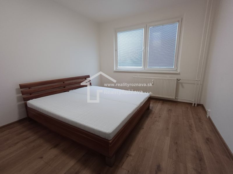 Schlafzimmer mit Bett und Holzboden in einer 3-Zimmer-Wohnung.