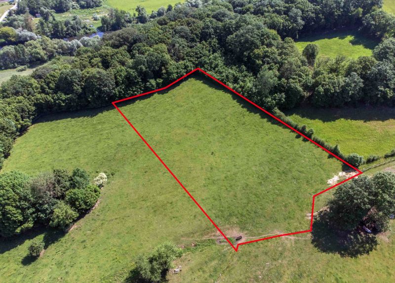 Luftaufnahme von Erholungsgrundstücken in Ostrá Lúka mit Wald im Hintergrund.