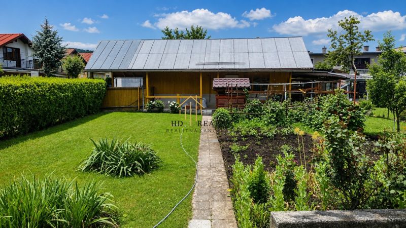 Ein Garten bei einem Einfamilienhaus in Slovenská Ľupča mit gepflegtem Rasen und kultivierten Pflanzen.