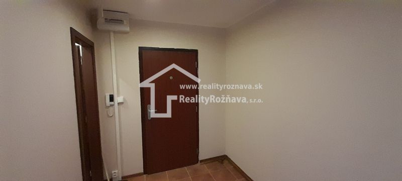Eingangsbereich mit brauner Tür in einer 2-Zimmer-Wohnung, Fliesenboden.