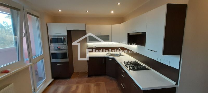 Küche in einer 2-Zimmer-Wohnung mit Holzboden und eingebauten Geräten.