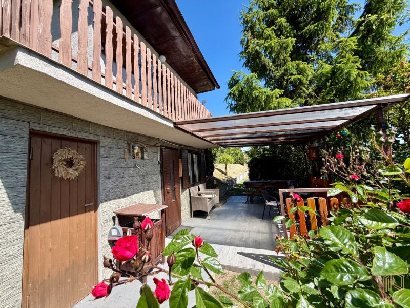 Ein Ferienhaus in Kunov bei Senica mit einem Holzbalkon und einer romantischen Terrasse voller Blumen.