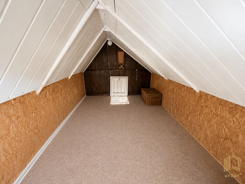 Dachboden der Hütte mit Holzeinrichtung und einem Rattankorb zur Aufbewahrung.