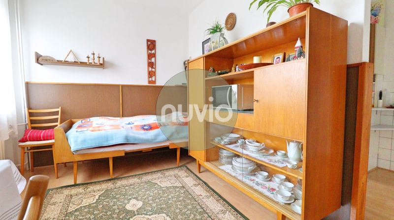 Ein Zimmer in einem Einfamilienhaus mit einem Bett, Retro-Möbeln und Regalen mit Porzellan.