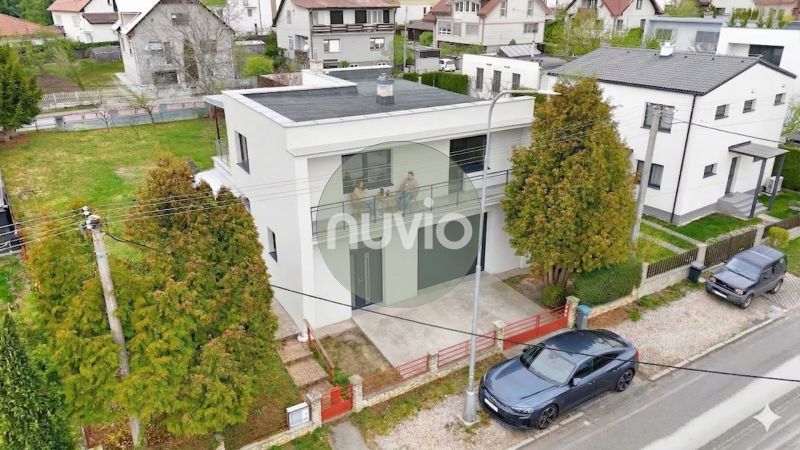 Ein Einfamilienhaus in Martin mit einem Flachdach, neben dem ein Auto parkt.