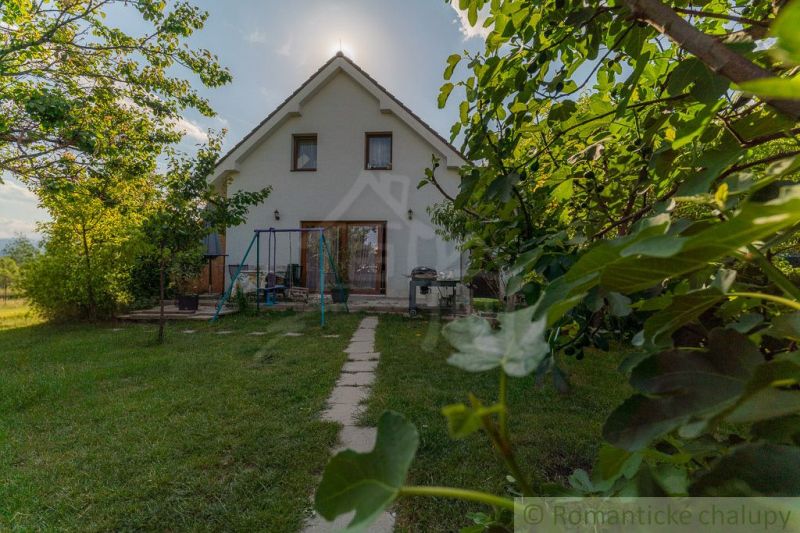 Einfamilienhaus in Bernolákovo mit großem Garten und einem Weg inmitten von Grün.