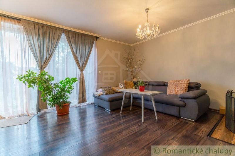 Wohnzimmer in einem Einfamilienhaus mit Sofa und Holzboden.