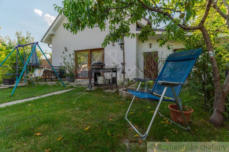 Der Garten eines Einfamilienhauses in Bernolákovo mit einer Schaukel, Gartenmöbeln und Grünflächen.