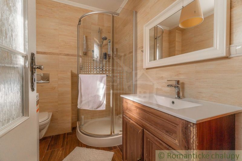 Badezimmer mit Holzdekor, Duschkabine und Waschbecken in einem Einfamilienhaus.