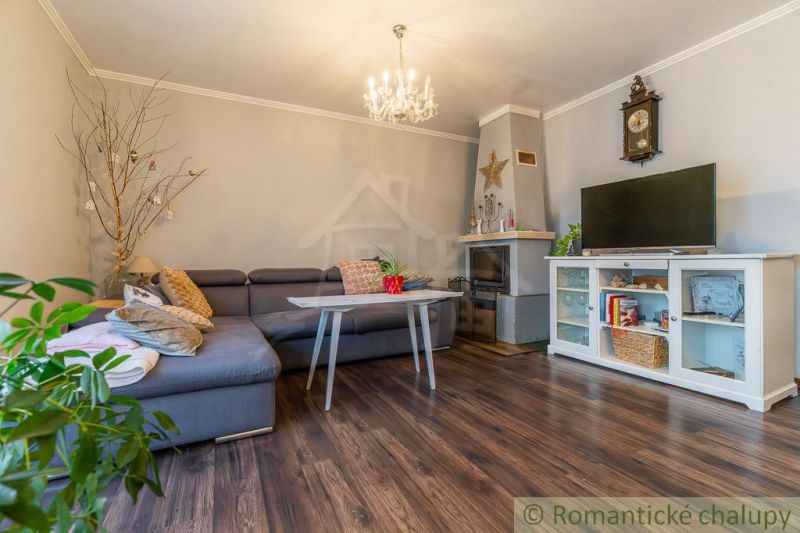 Wohnzimmer in einem Einfamilienhaus mit Kamin, Ecksofa und Holzboden.