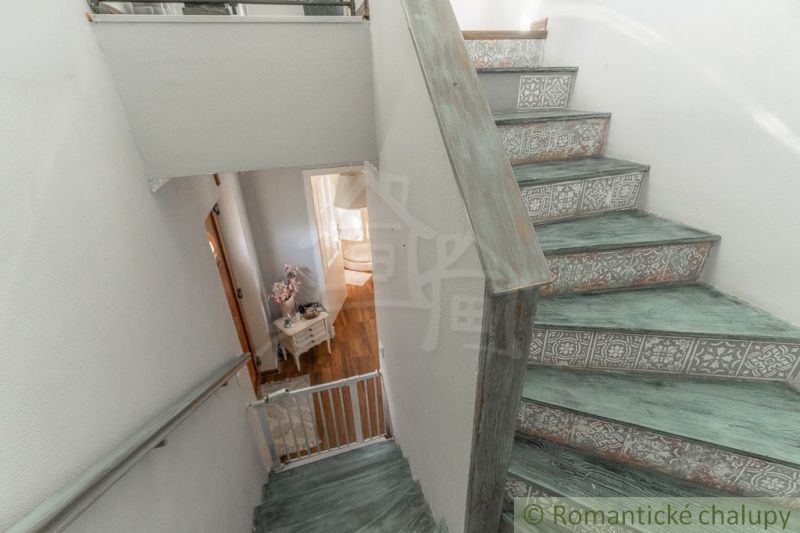Treppe im Einfamilienhaus mit dekorativen Mustern und einem Boden in Holzoptik.