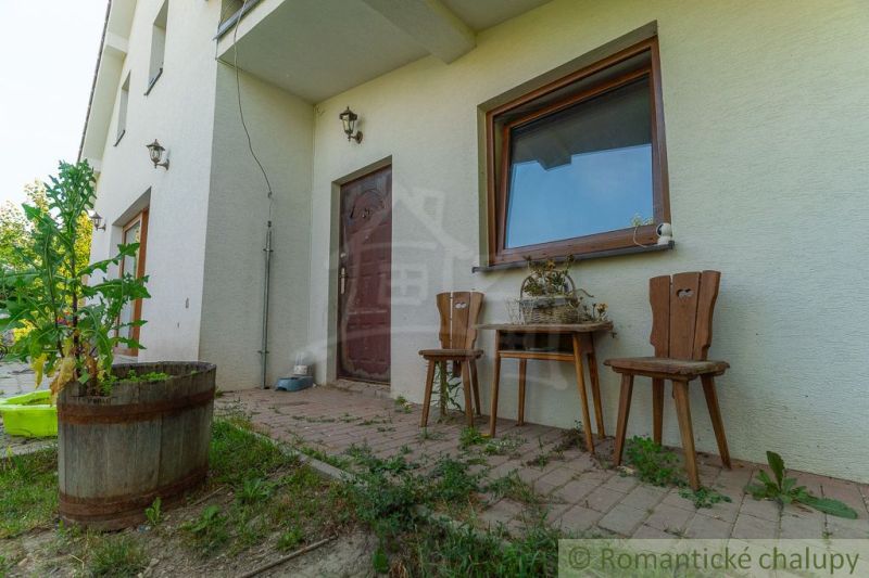 Das Äußere eines Einfamilienhauses in Bernolákovo mit Terrasse und Holzmöbeln.