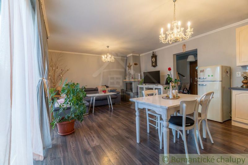 Innenraum eines Einfamilienhauses mit Holzboden, Esstisch und Sitzgarnitur.