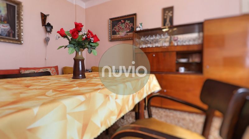 Esszimmer in einem Einfamilienhaus mit Holzmöbeln und einem Tisch mit Blumen auf einer Tischdecke.