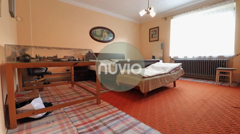 Schlafzimmer mit einem sanft orangefarbenen Teppich und einer Modelleisenbahn in einem Einfamilienhaus.