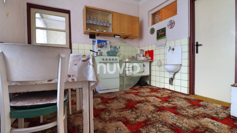 Küche in einem Einfamilienhaus mit Teppich, Esstisch und Gasherd.